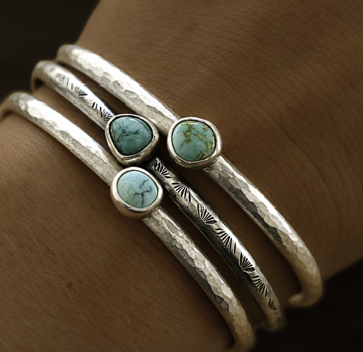 Three hand-forged silver cuff bracelets set with turquoise